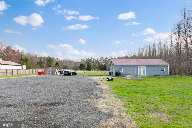 a view of backyard of house and car parked