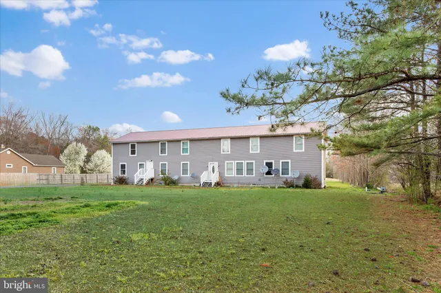 a view of a house with a big yard and a large tree