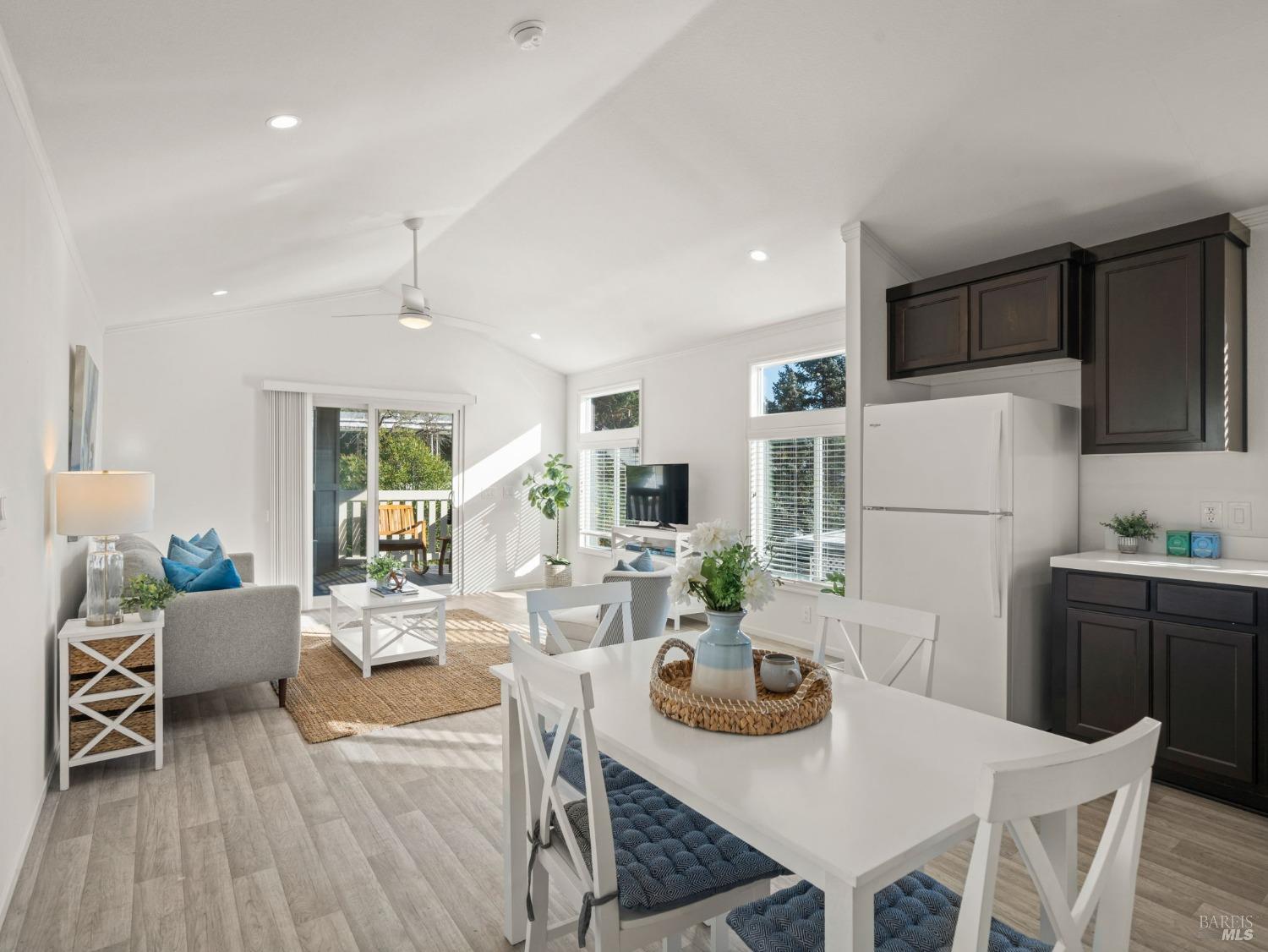 a view of a dining room with furniture a kitchen and chandelier