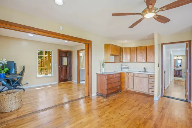 a large kitchen with cabinets wooden floor and stainless steel appliances
