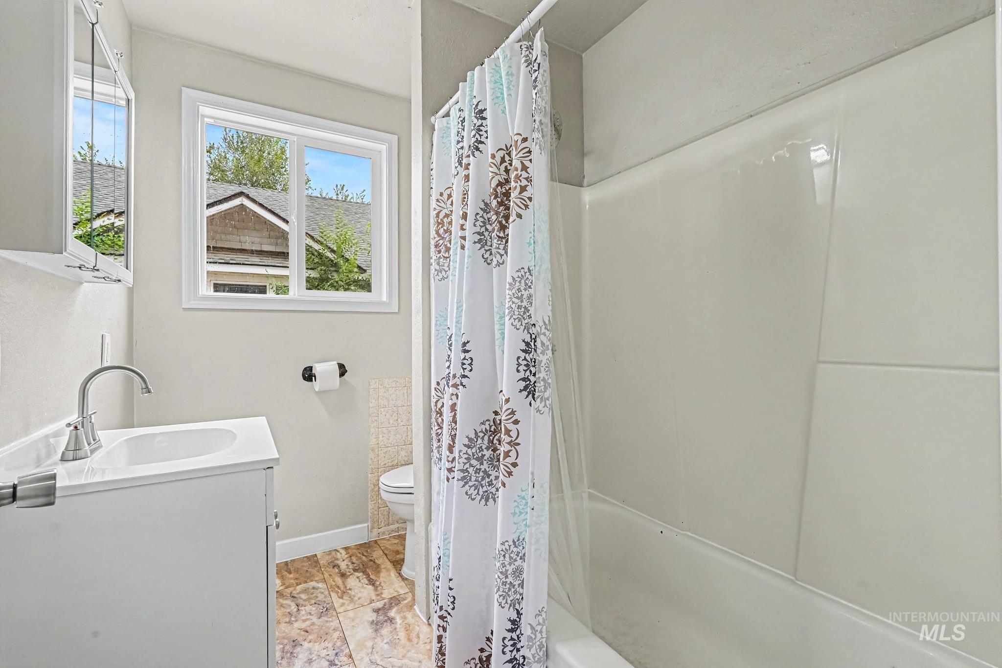 1023 State Street Weiser, ID 83672 - Photo 11 of 25 Bathroom featuring a single vanity with a white cabinet, a white sink, and a chrome faucet