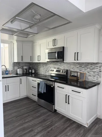 a kitchen with granite countertop a sink and cabinets