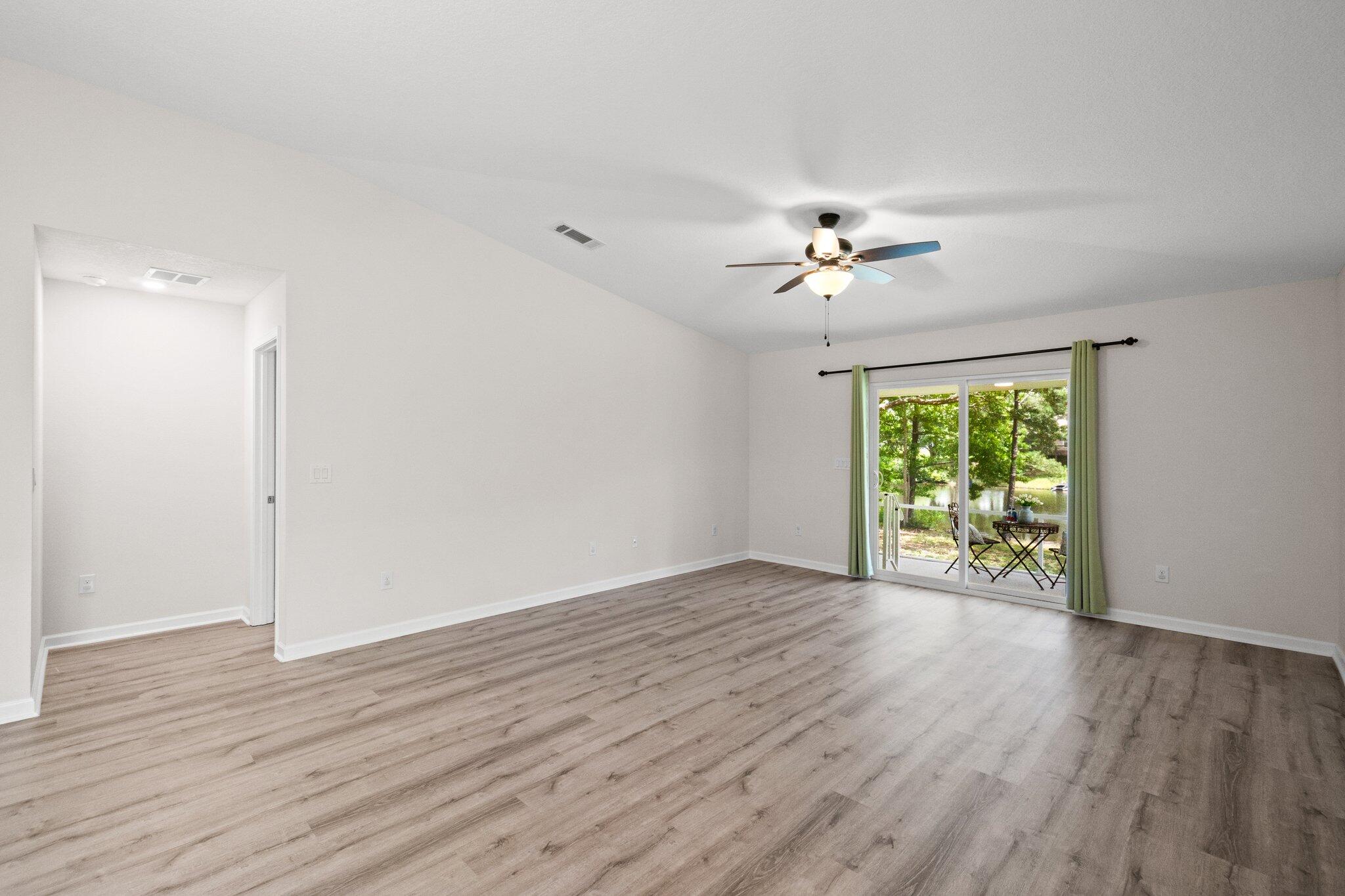 378 Marquis Way Freeport, FL 32439 - Photo 12 of 37 wooden floor in an empty room with a window