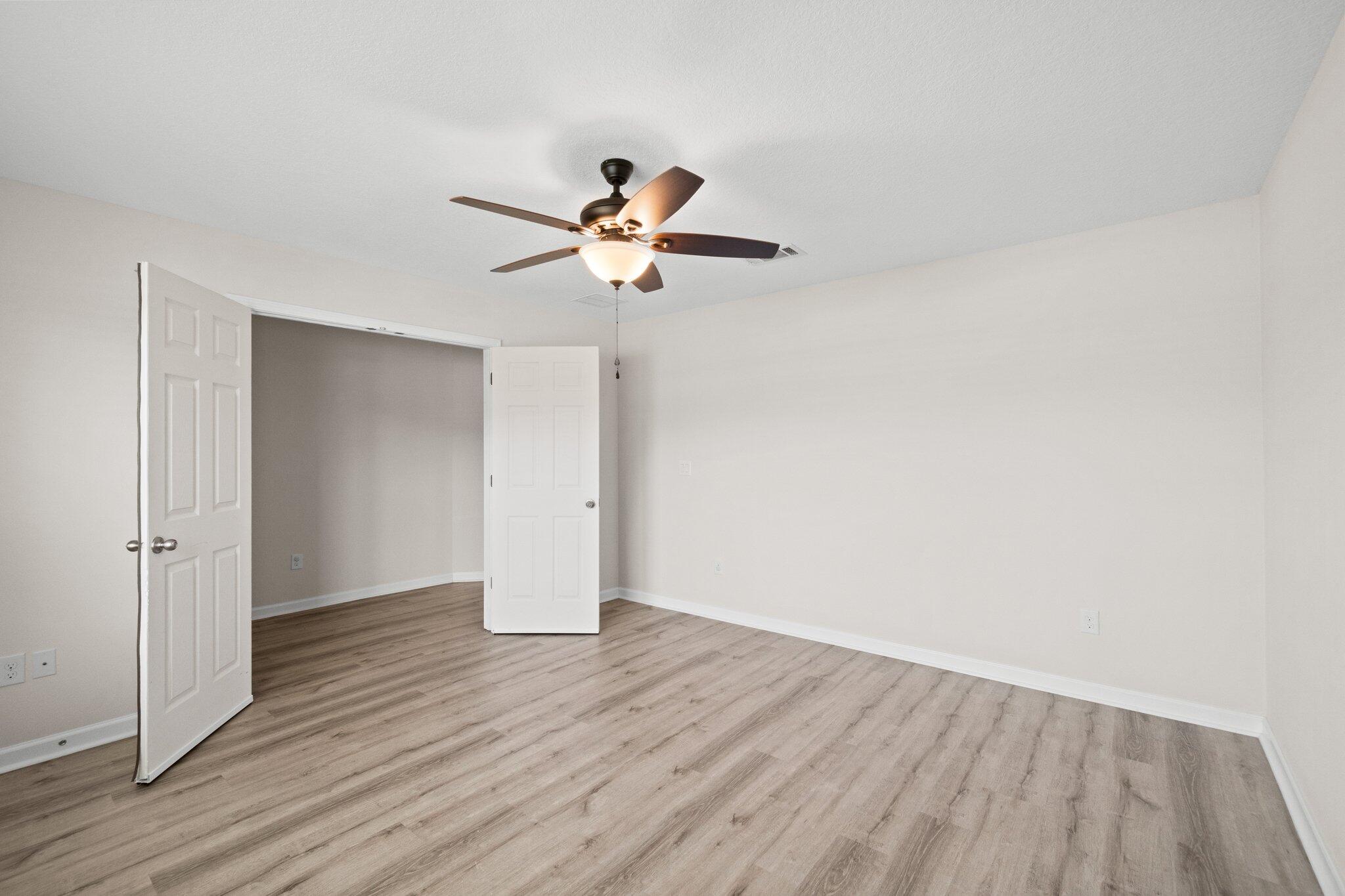 378 Marquis Way Freeport, FL 32439 - Photo 22 of 37 an empty room with wooden floor and a ceiling fan