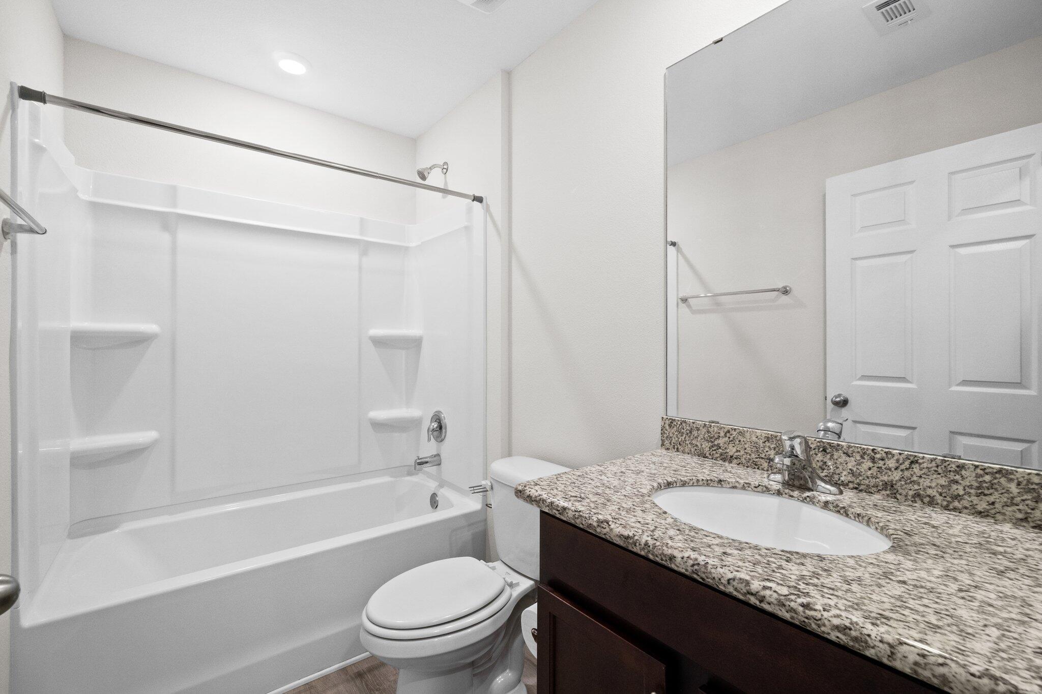 378 Marquis Way Freeport, FL 32439 - Photo 32 of 37 a bathroom with a granite countertop sink toilet and shower