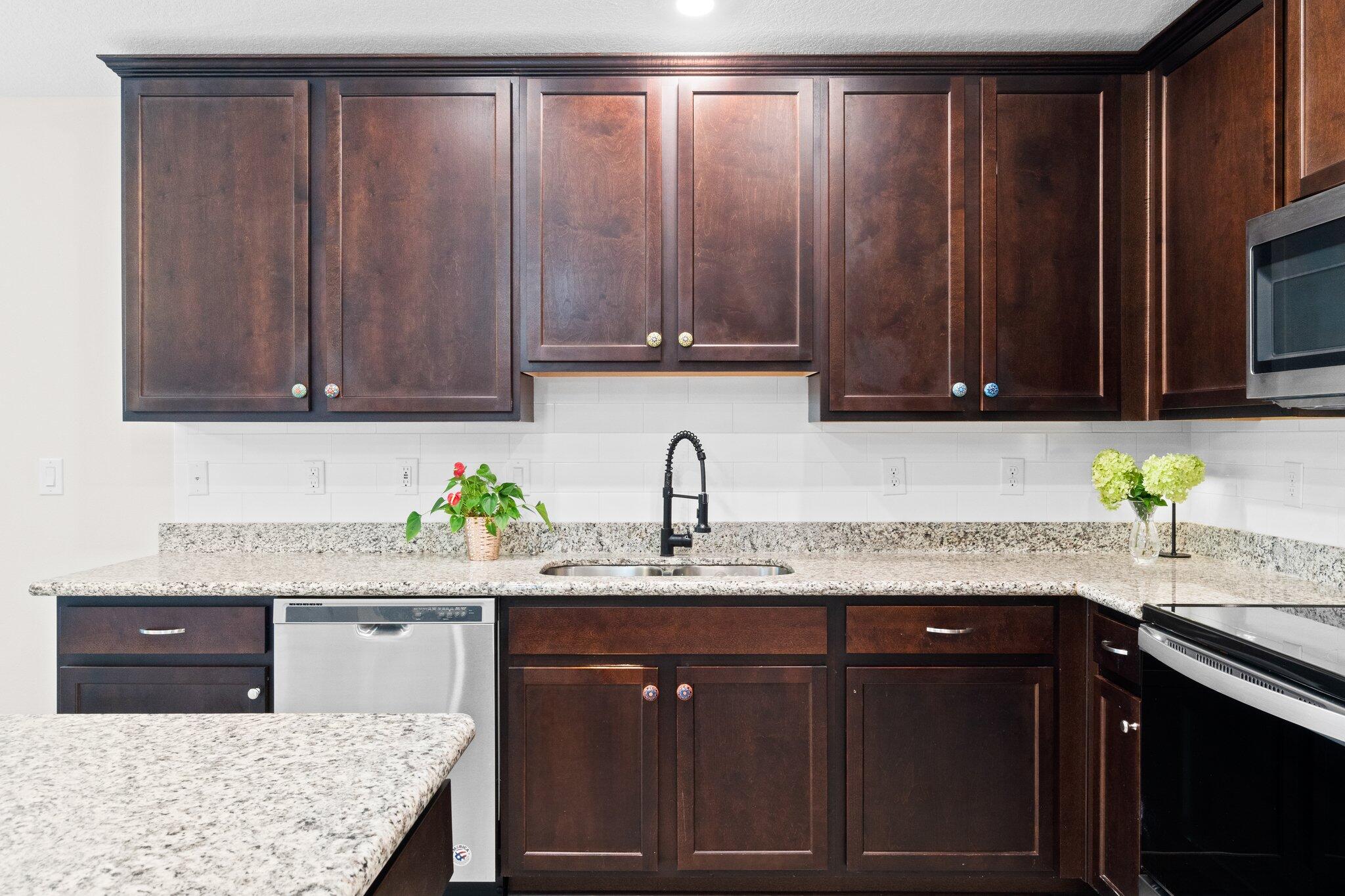 378 Marquis Way Freeport, FL 32439 - Photo 9 of 37 a kitchen with granite countertop wooden cabinets a sink and dishwasher