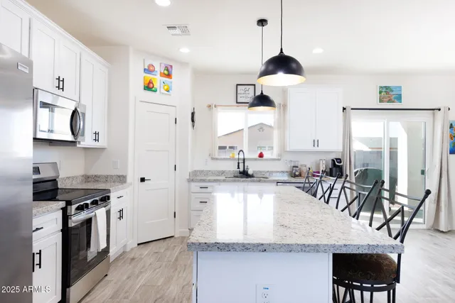 a kitchen with stainless steel appliances granite countertop a stove a sink and a refrigerator