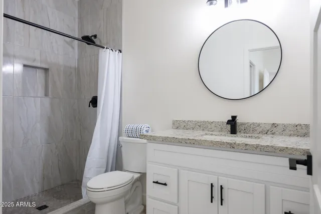 a bathroom with a granite countertop sink toilet and a mirror