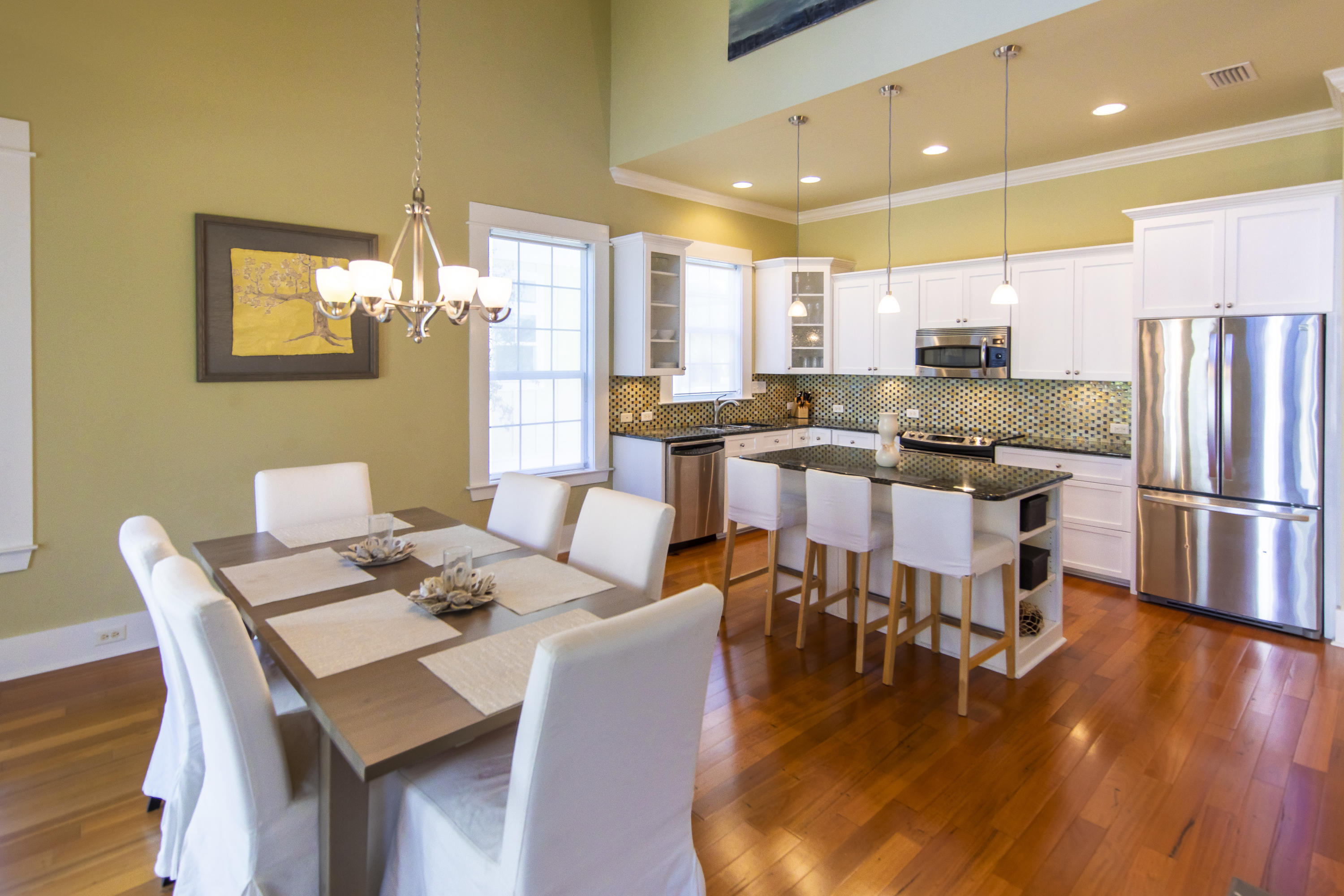 276 Grande Pointe Circle Inlet Beach, FL 32461 - Photo 9 of 33 a dining room with stainless steel appliances kitchen island granite countertop a dining table chairs and a refrigerator