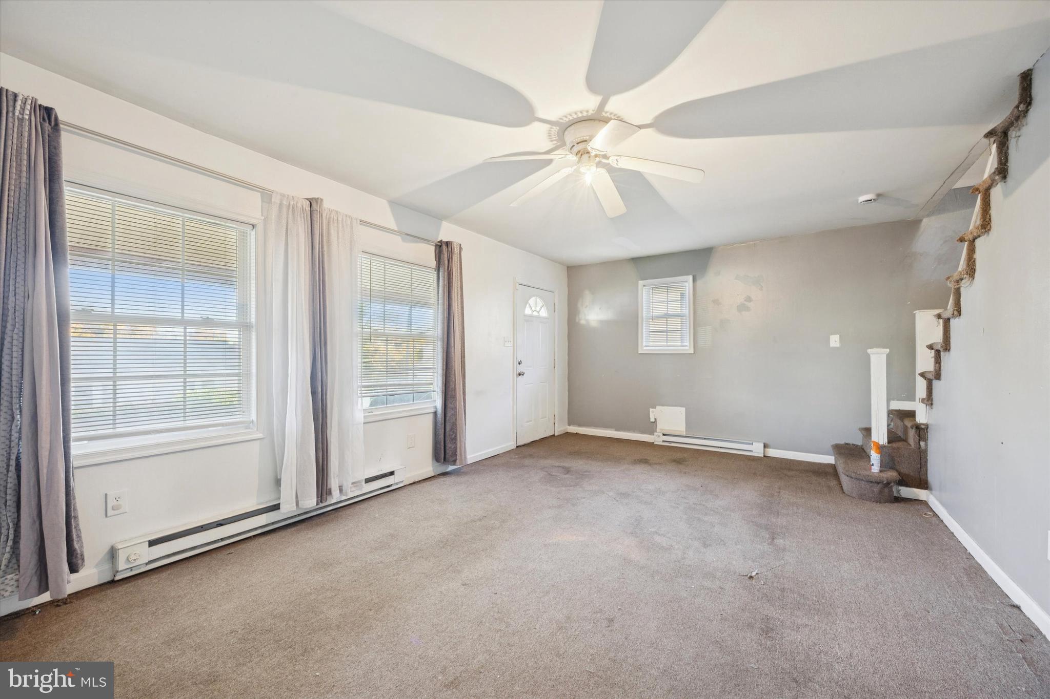 1004 Sunset Street Marcus Hook, PA 19061 - Photo 4 of 19 an empty room with chandelier fan and windows