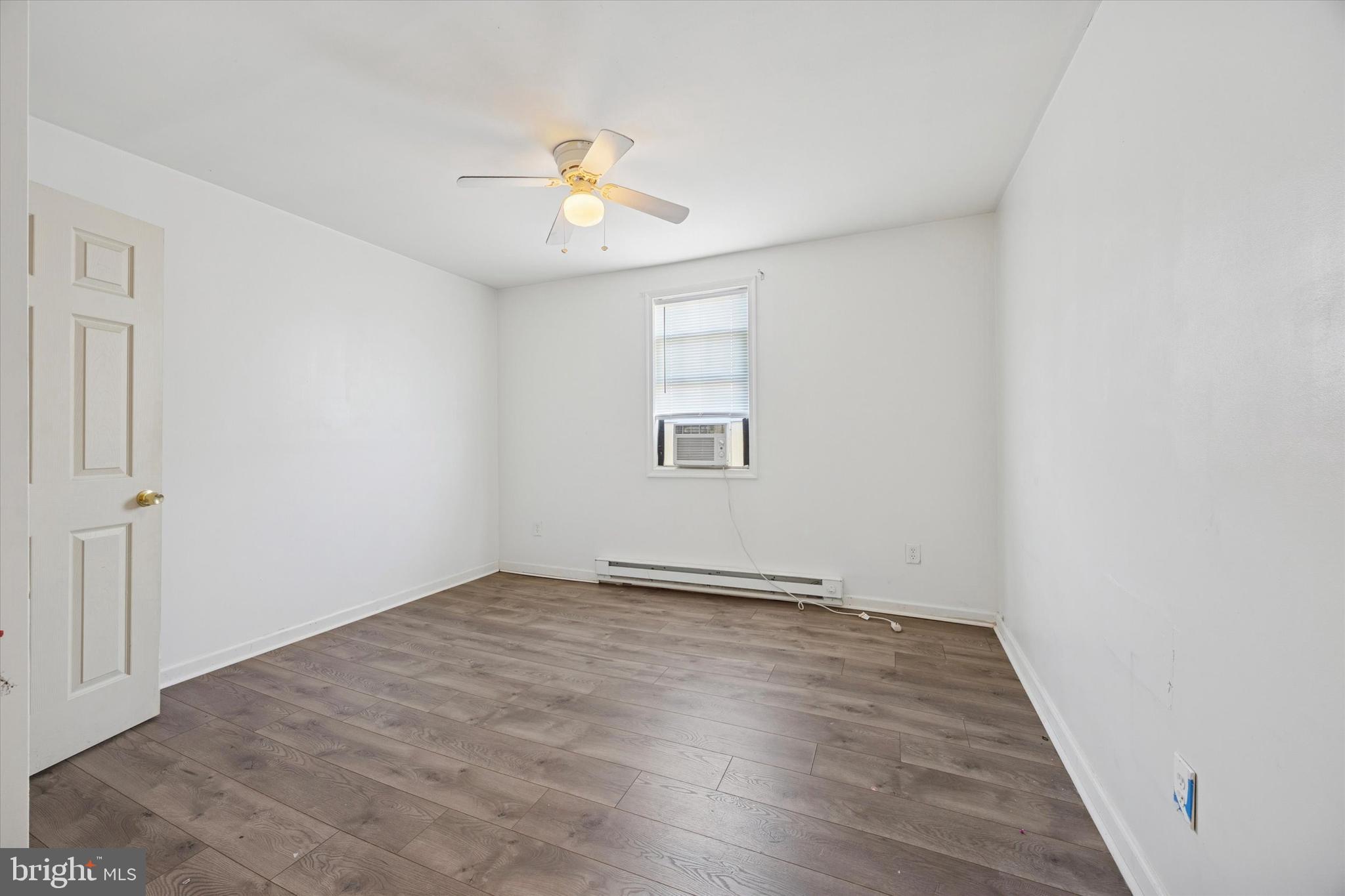 1004 Sunset Street Marcus Hook, PA 19061 - Photo 10 of 19 an empty room with wooden floor and windows