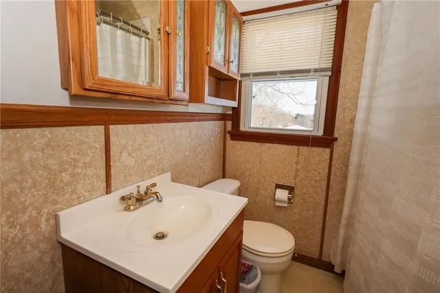 a bathroom with a sink a toilet and a mirror