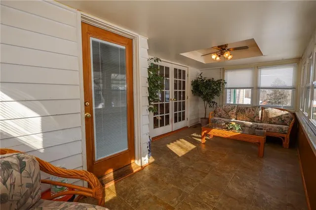 a backyard of a house with sofas table and chairs