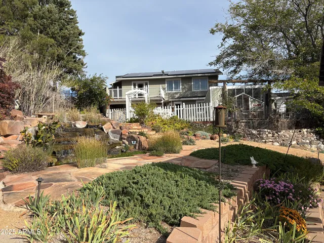 a view of a patio with table and chairs potted plants and large tree