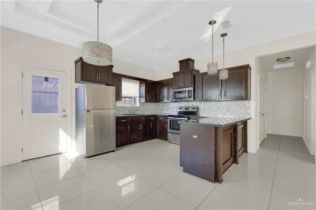 a kitchen with stainless steel appliances granite countertop a sink a counter space and cabinets