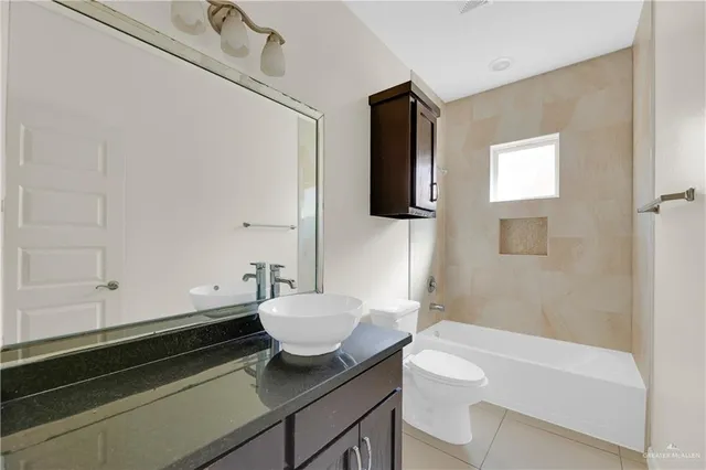 a bathroom with a granite countertop sink a toilet and bathtub