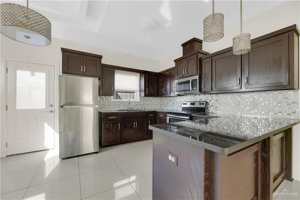 a kitchen with stainless steel appliances granite countertop a refrigerator a stove a sink dishwasher and a refrigerator