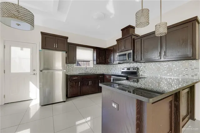 a kitchen with stainless steel appliances granite countertop a refrigerator a stove a sink dishwasher and a refrigerator