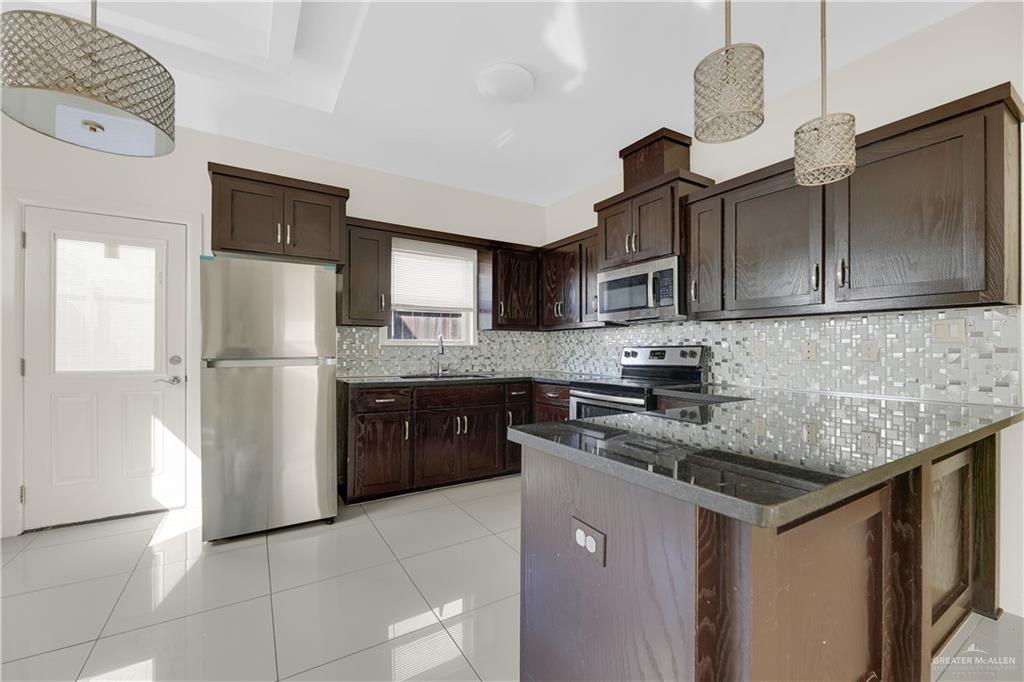 1017 East Myrtle Beach Avenue McAllen, TX 78503 - Photo 8 of 18 a kitchen with stainless steel appliances granite countertop a refrigerator a stove a sink dishwasher and a refrigerator