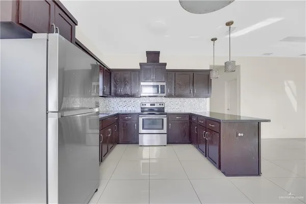 a kitchen with stainless steel appliances granite countertop a refrigerator and a stove