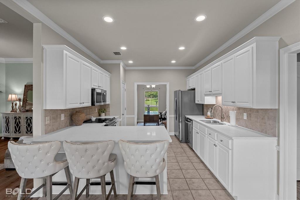 116 Augusta Avenue Benton, LA 71006 - Photo 15 of 38 a large kitchen with kitchen island granite countertop lots of white cabinets a sink and appliances