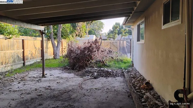 a view of a dry yard with wooden fence