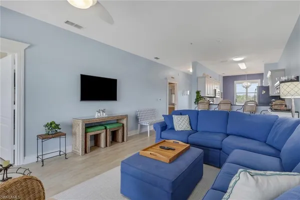 a living room with furniture a flat screen tv and kitchen view