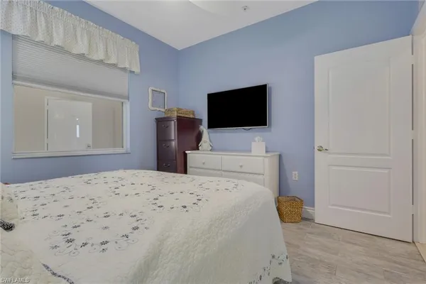 a bedroom with a bed and a flat screen tv