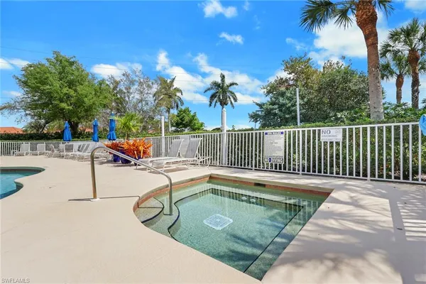 a view of a swimming pool with a patio and wooden fence