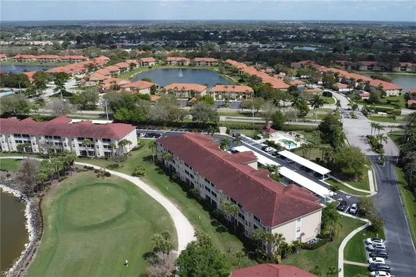 an aerial view of residential houses with outdoor space and lake view