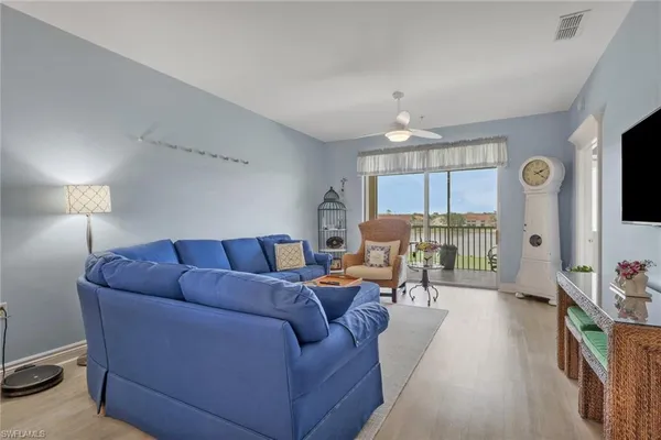 a living room with furniture a chandelier and a window