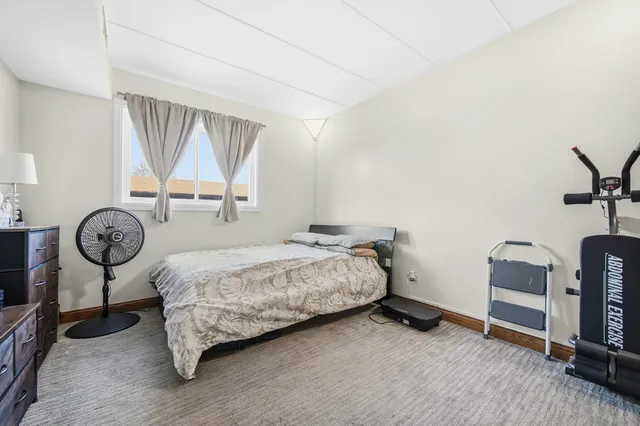 a bedroom with a bed a mirror and a window