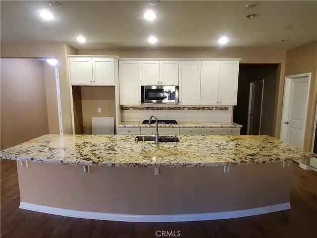 a view of a kitchen with kitchen island a counter top space and stainless steel appliances