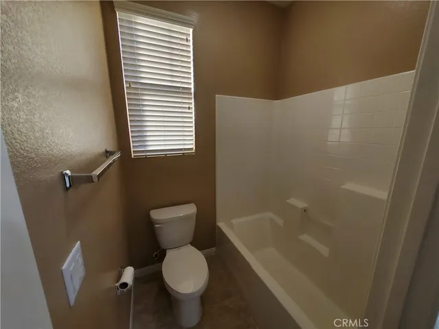 a white toilet sitting next to a bath tub