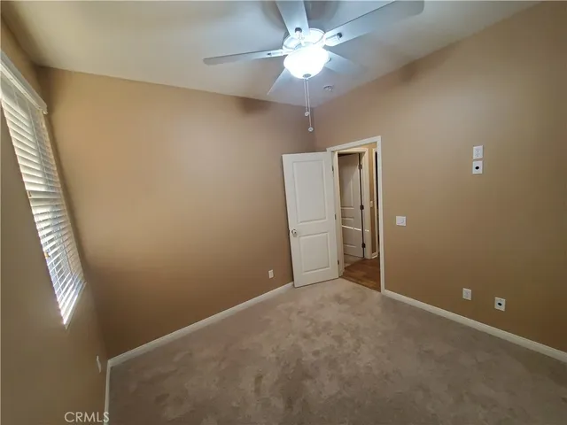 en empty room with windows and fan