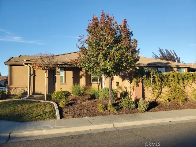 a view of a house with a cars park side of a road