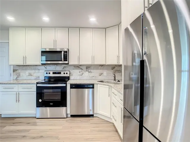 a kitchen with stainless steel appliances a refrigerator stove and sink