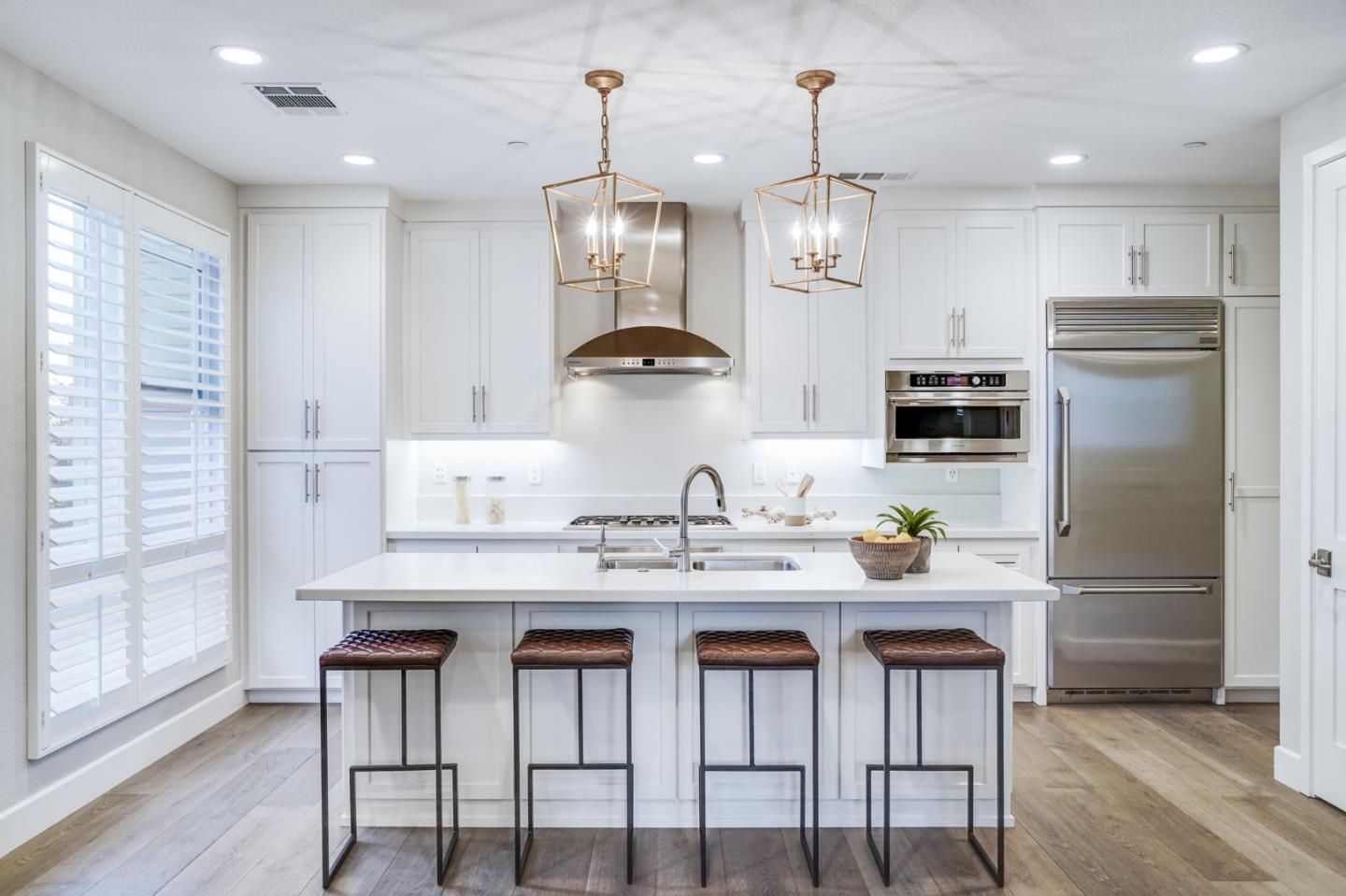 416 Neves Road San Mateo, CA 94403 - Photo 16 of 40 a kitchen with stainless steel appliances kitchen island granite countertop a dining table chairs and white cabinets