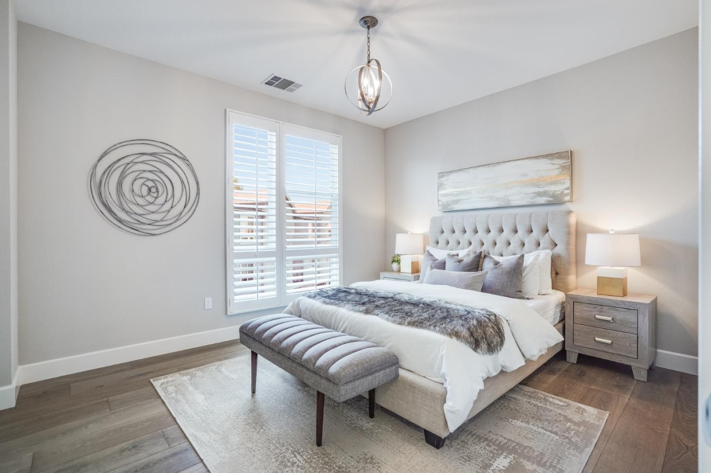 416 Neves Road San Mateo, CA 94403 - Photo 23 of 40 a spacious bedroom with a bed and a chandelier