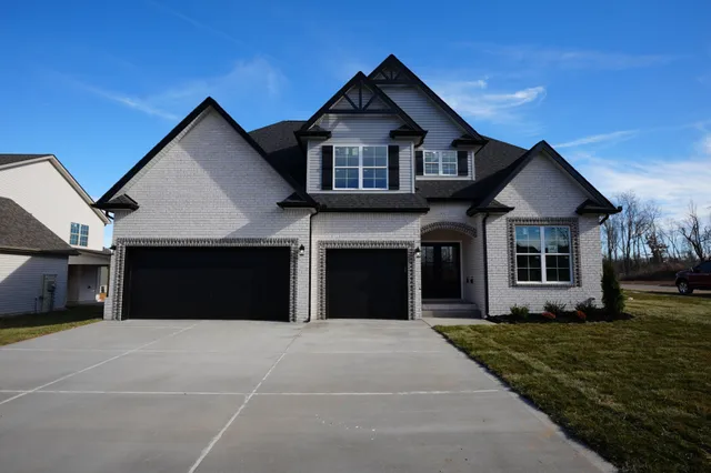 a front view of a house with a garden and yard