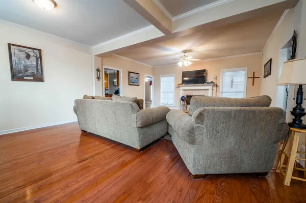 a kitchen with stainless steel appliances granite countertop a stove a sink a oven and a view of living room