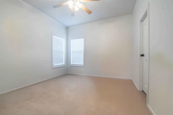 a view of a livingroom with a chandelier fan and wooden floor