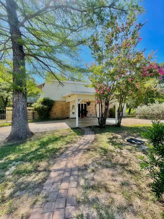 a view of a house with backyard and a tree