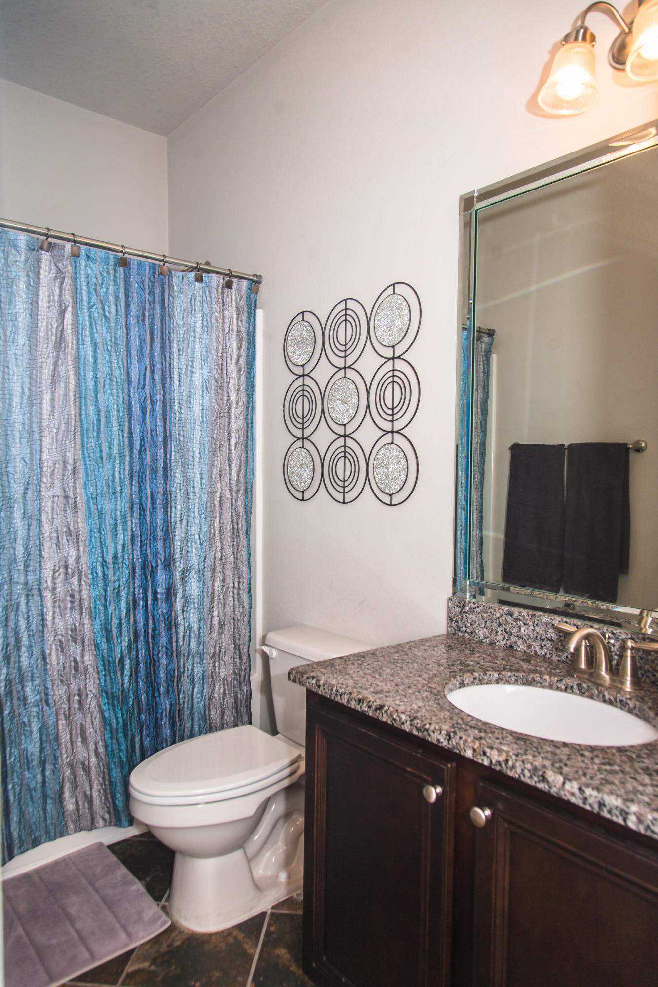 282 Whispering Lake Drive Santa Rosa Beach, FL 32459 - Photo 14 of 18 a bathroom with a granite countertop toilet sink and mirror