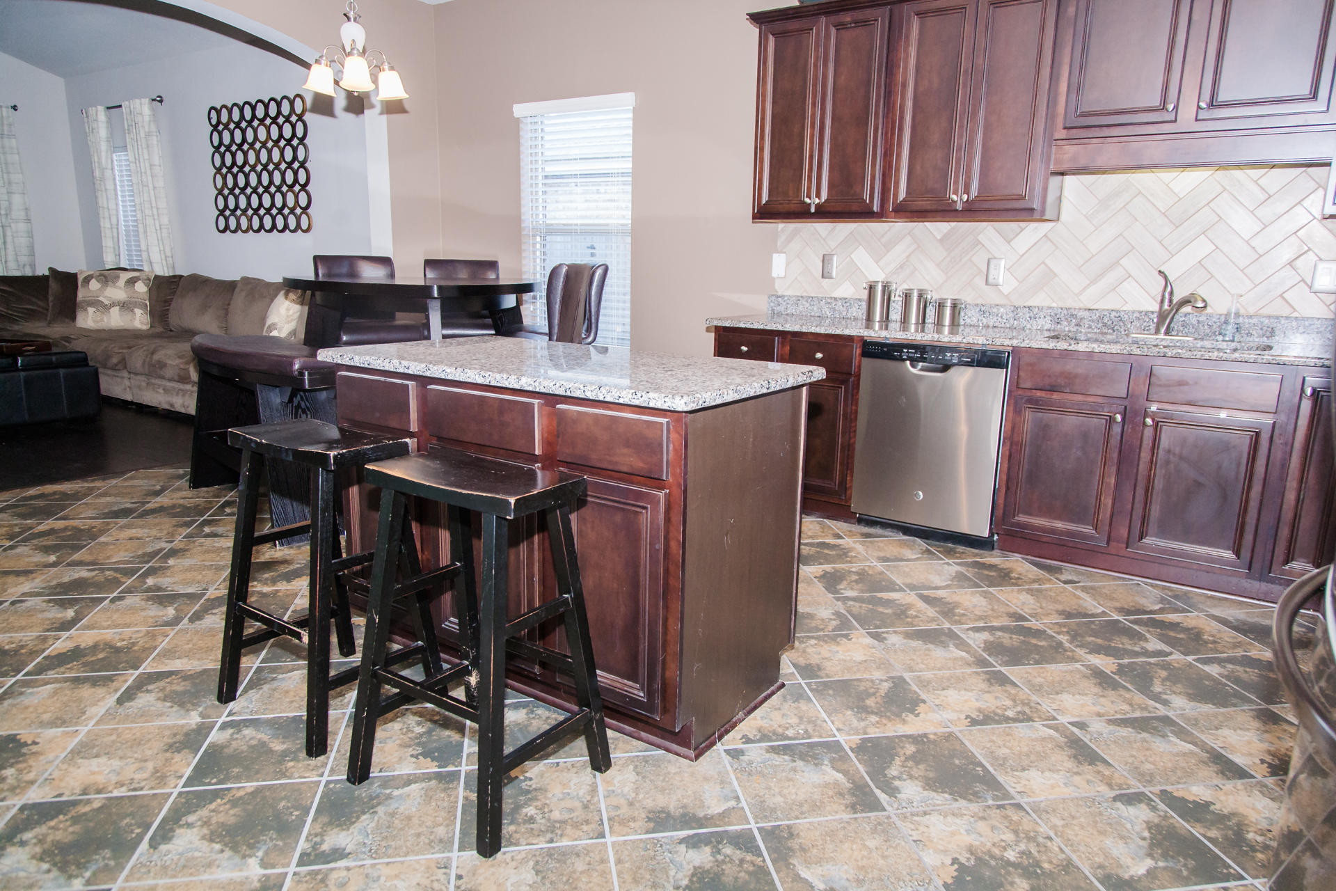 282 Whispering Lake Drive Santa Rosa Beach, FL 32459 - Photo 7 of 18 a kitchen with stainless steel appliances granite countertop a table chairs sink and cabinets