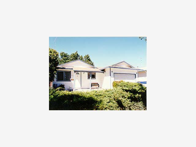 a view of a white house with a yard and sitting space