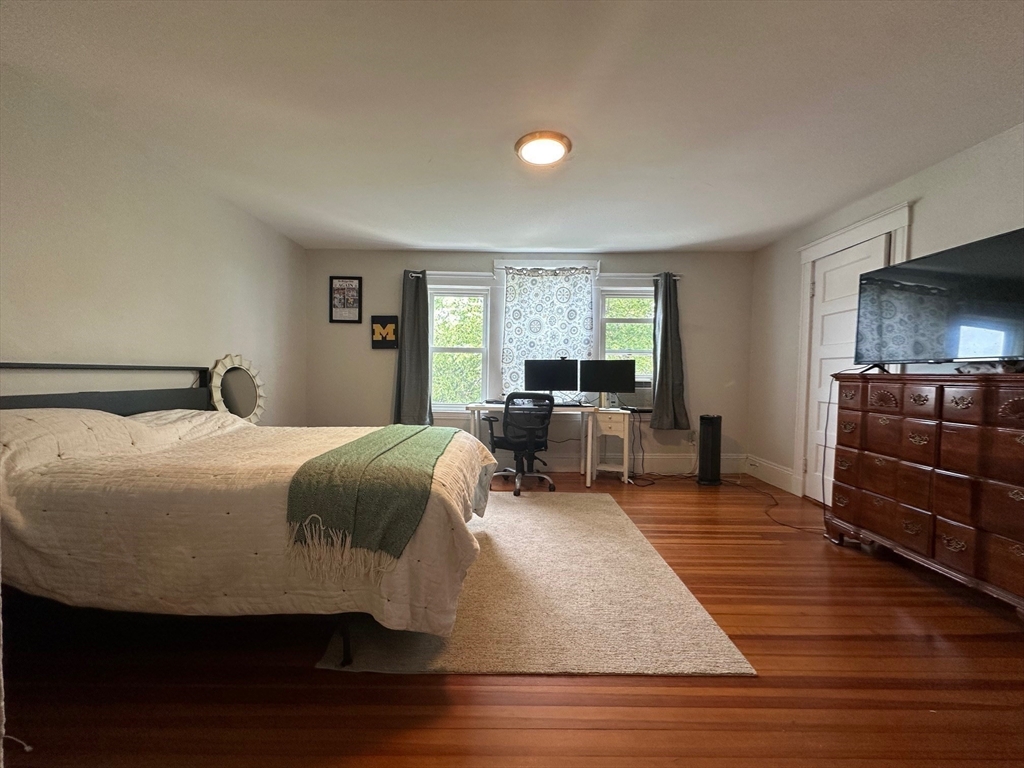 62 Bromfield Road, Unit 2 Somerville, MA 02144 - Photo 8 of 14 a bedroom with a bed and wooden floor