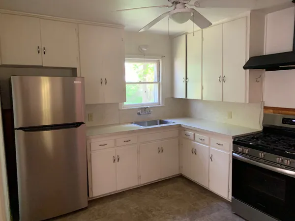 a kitchen with a refrigerator sink and cabinets
