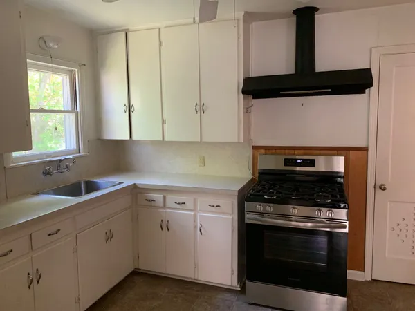 a kitchen with white cabinets and black appliances