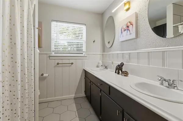 a bathroom with a granite countertop sink and a window